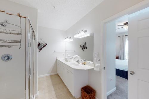 een witte badkamer met een wastafel en een douche bij Windemere 406 in Perdido Key
