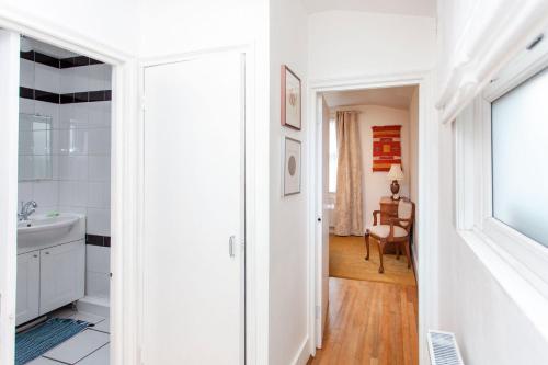 a white bathroom with a sink and a mirror at Italianflat - Kilburn Art Style in London