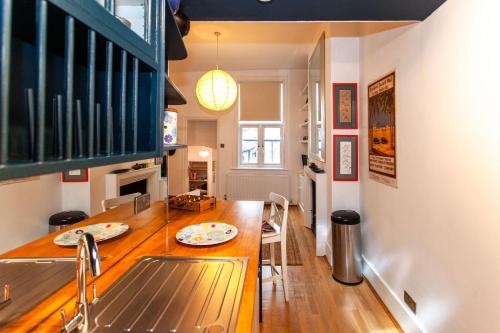 a kitchen with a sink and a table with plates on it at Italianflat - Kilburn Art Style in London
