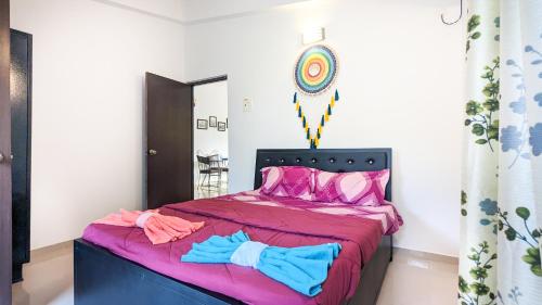 1 dormitorio con 1 cama con sábanas rosas y azules en Poolside Paradise 1Bhk Luxury Apartment in Siolim. en Siolim