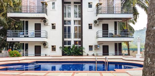 un edificio con piscina frente a un edificio en Poolside Paradise 1Bhk Luxury Apartment in Siolim. en Siolim