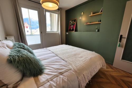 une chambre avec un grand lit et une fenêtre dans l'établissement Bertholet Annecy centre, à Annecy