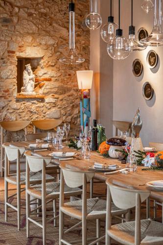 a restaurant with wooden tables and chairs and a stone wall at Paradis Agricole in Pietrasanta