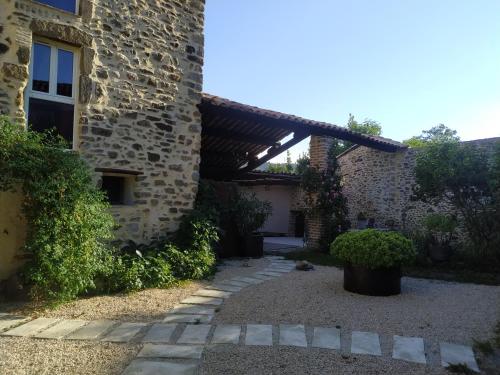 une cour d'un bâtiment avec un auvent en bois dans l'établissement La ferme Ranc - gite le levant, à Gagnières