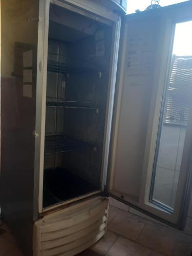 an empty refrigerator in a room with a window at Caruaru eventos e lazer in Caruaru