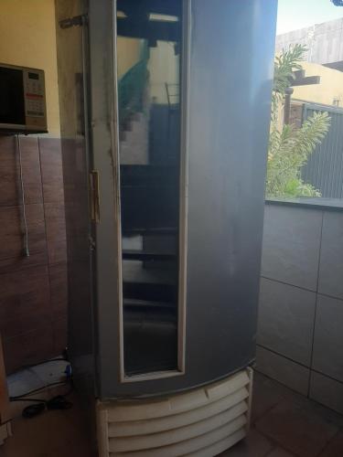 a bathroom with a glass cabinet with a window at Caruaru eventos e lazer in Caruaru