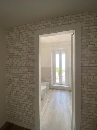 a bathroom with a brick wall and a doorway at Rosso Conero - Le Grotte Rooms & Apartments in Camerano