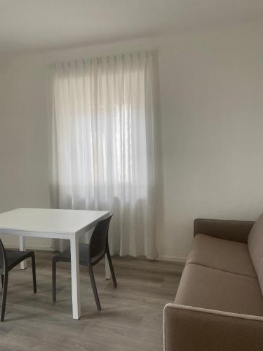 a living room with a white table and a couch at Rosso Conero - Le Grotte Rooms & Apartments in Camerano