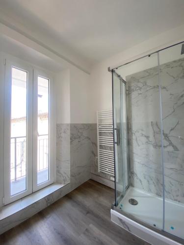 卡梅拉諾的住宿－Rosso Conero - Le Grotte Rooms & Apartments，一间带玻璃淋浴和窗户的浴室