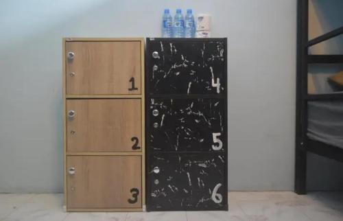 a book shelf next to a locker with numbers on it at The Lion House in Khlaung Phai Bae