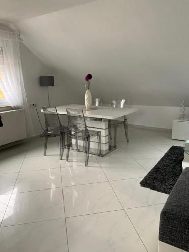 a white dining room with a table and chairs at Herz der Weinberge in Gemmrigheim