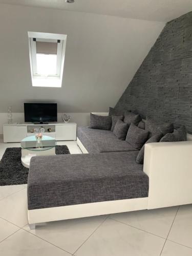 ein Wohnzimmer mit einem Sofa und einem TV in der Unterkunft Herz der Weinberge in Gemmrigheim