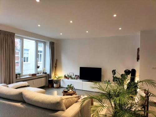 uma sala de estar com um sofá e uma televisão em Sea la vie em Oostende