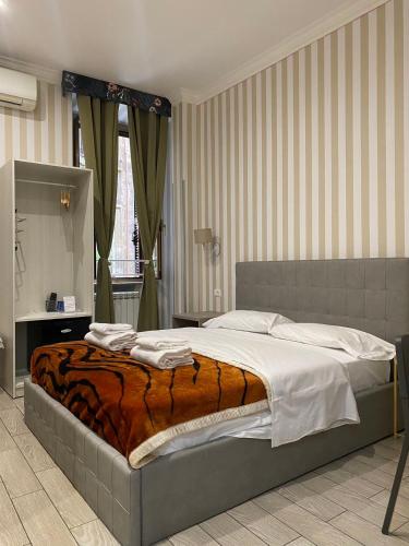 a bedroom with a bed with a comforter on it at fabio rooms 102 in Rome