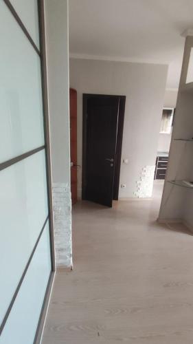 ein leeres Zimmer mit einer schwarzen Tür und einem Holzboden in der Unterkunft New vip 278 in Agaraki