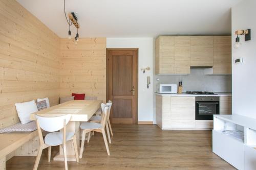 Il comprend une cuisine et une salle à manger avec une table et des chaises en bois. dans l'établissement WoodenKey Asiago bicamere immerso nel verde, à Asiago