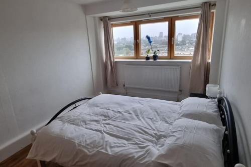 a white bed in a room with a window at Gottersea 1 bedroom flat in Battersea 70 mq in London