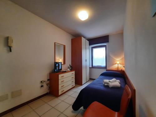 een slaapkamer met een bed met een knuffeldier erop bij Albergo Martina in Chiusaforte