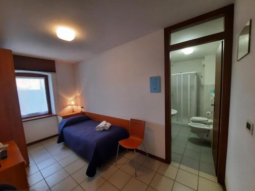 a bedroom with a bed and a bathroom with a toilet at Albergo Martina in Chiusaforte