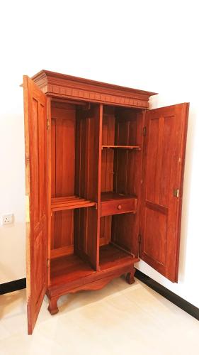 an old wooden cabinet with shelves on a wall at Tropical Inn in Mirissa