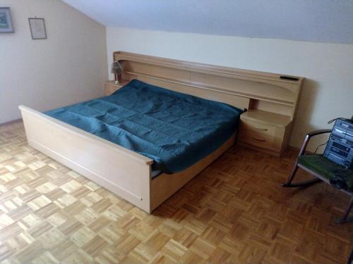 1 dormitorio con 1 cama con sábanas azules y silla en Ferienwohnung Villmar en Villmar