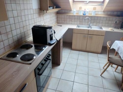 uma pequena cozinha com um fogão e um lavatório em Ferienwohnung Villmar em Villmar