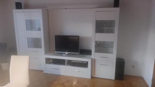 a living room with a tv and a white entertainment center at Ferienwohnung Villmar in Villmar