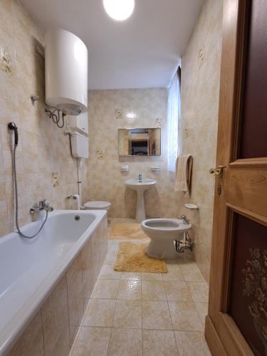 a bathroom with a tub and a toilet and a sink at Villa Adriana in Tenno