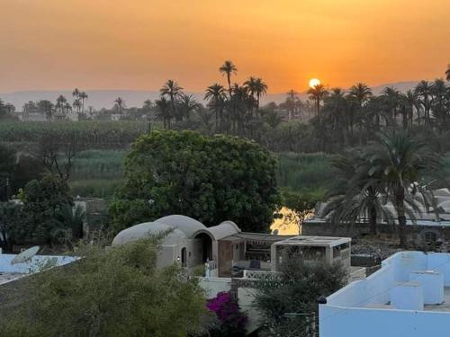 een uitzicht op een huis met een zonsondergang op de achtergrond bij Rose travel_trips in Jazīrat al ‘Awwāmīyah