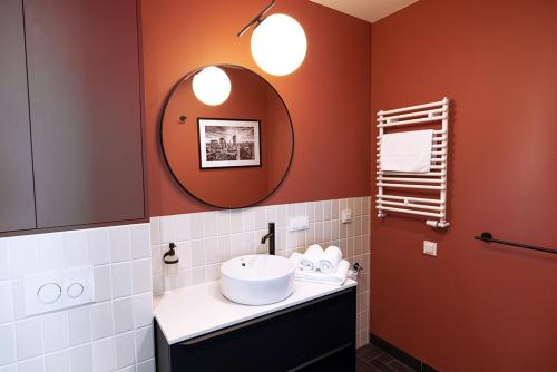een badkamer met een wastafel en een spiegel bij B85 Suites in Warschau