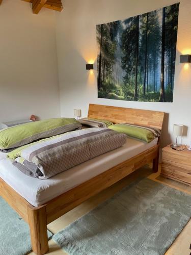 een slaapkamer met een houten bed en een schilderij aan de muur bij Dachgeschosswohnung mit traumhaftem Zugspitzblick bei Garmisch in Farchant