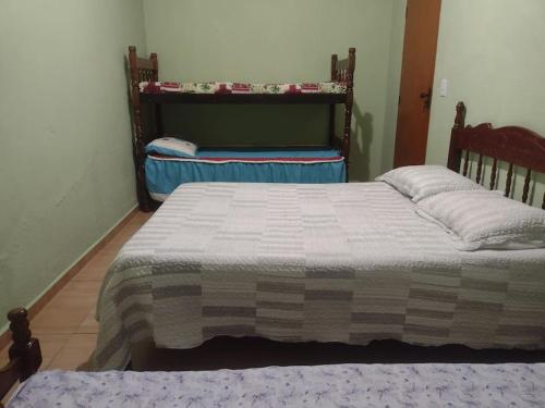 a bedroom with a bed with a blanket on it at Estância Martins in Extrema