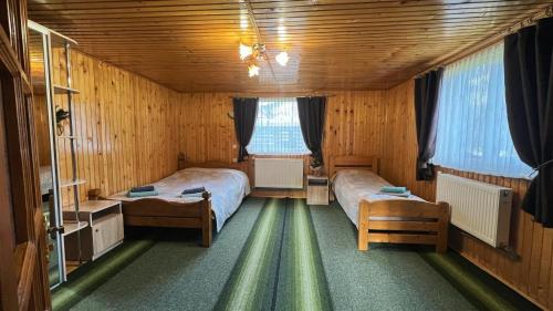 タターリウにあるBeskyd Holidayの木製の部屋にベッド2台が備わるベッドルーム1室