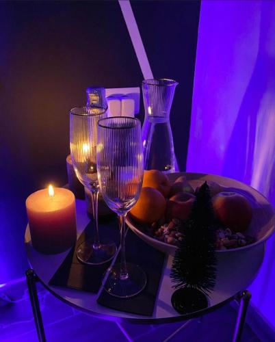 una mesa con dos copas de vino y una vela en LUXSPAKR, en Kranj