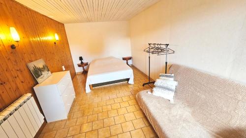 Cette chambre comprend un lit et un canapé. dans l'établissement Gîte l'étang des Soays, étang de pêche privé, à Saint-Émiland