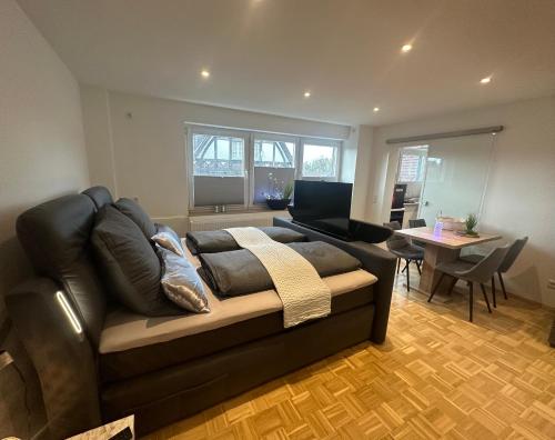 a living room with a black couch and a table at MyHome-Tiny -stilvollen Ruhepol in Lüdinghausen