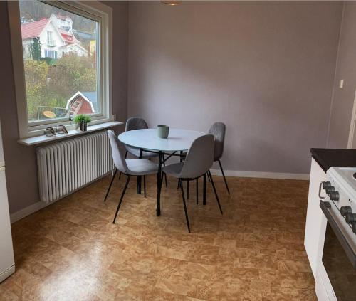 una mesa y sillas en una cocina con ventana en Iris en Huskvarna