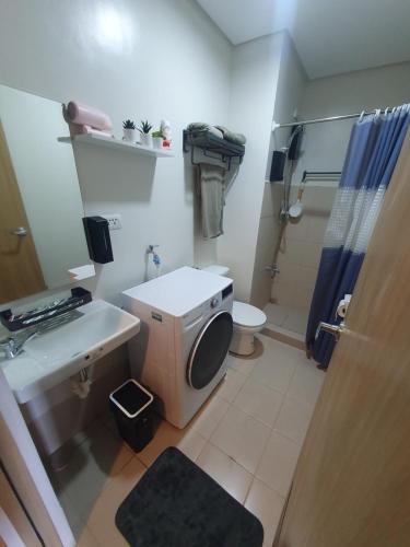 a bathroom with a sink and a toilet and a shower at Hector's Place at SMDC Vine Residences in Manila