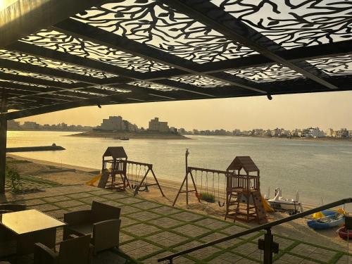 two playgrounds on the shore of a body of water at منتجع اووه يامال البحري في الخيران OOh Yaa Mal in Al Khīrān