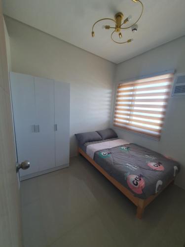 a small bedroom with a bed and a window at Hector's Place at SMDC Vine Residences in Manila