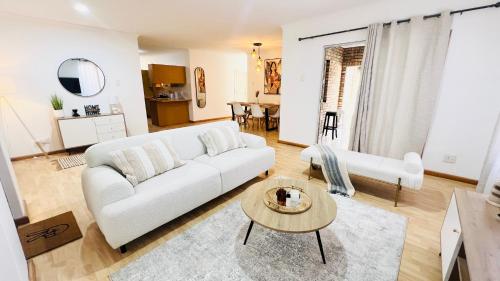 a living room with a white couch and a table at Luxury Modern Home in Summerstrand