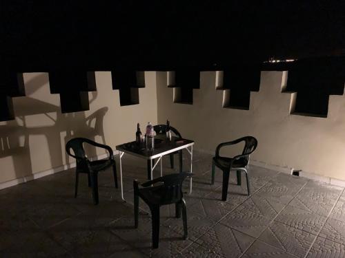 a table and two chairs in a dark room at Castello Bianco in Shabīkah