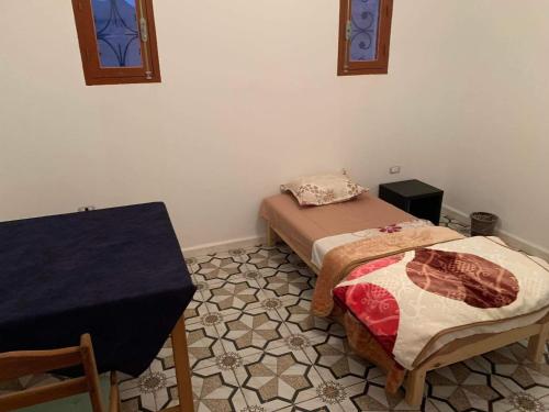 a room with two twin beds and a table at Castello Bianco in Shabīkah