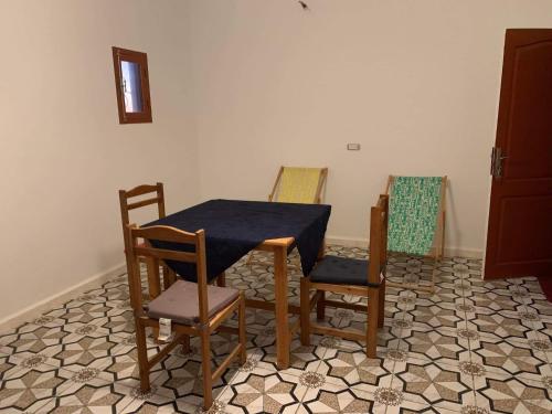 a dining room with a table and four chairs at Castello Bianco in Shabīkah
