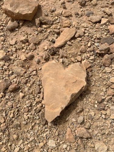 a heart shaped rock sitting on the ground at Castello Bianco in Shabīkah