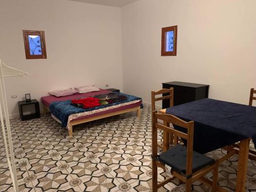 a bedroom with a bed and a table and chairs at Castello Bianco in Shabīkah