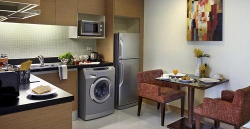 a kitchen with a refrigerator and a table with chairs at Lohas Residences Sukhumvit 2 in Bangkok