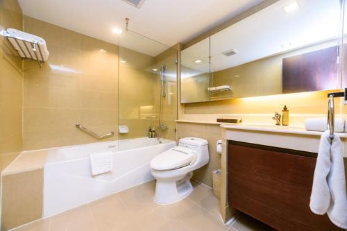 a bathroom with a tub and a toilet and a sink at Lohas Residences Sukhumvit 2 in Bangkok