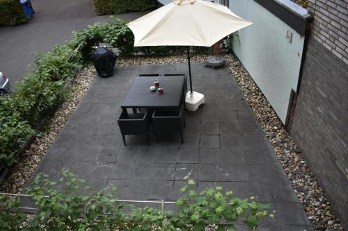 a patio with a table and an umbrella at MyHome-Tiny -stilvollen Ruhepol in Lüdinghausen