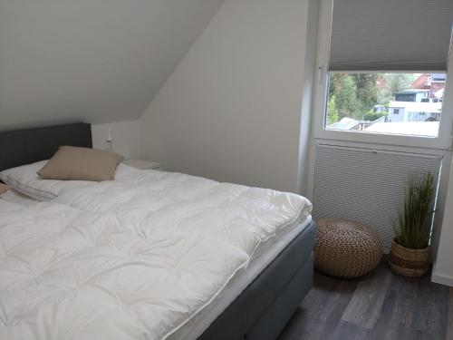 a white bed in a room with a window at Nordseehus-HYGGE in Butjadingen